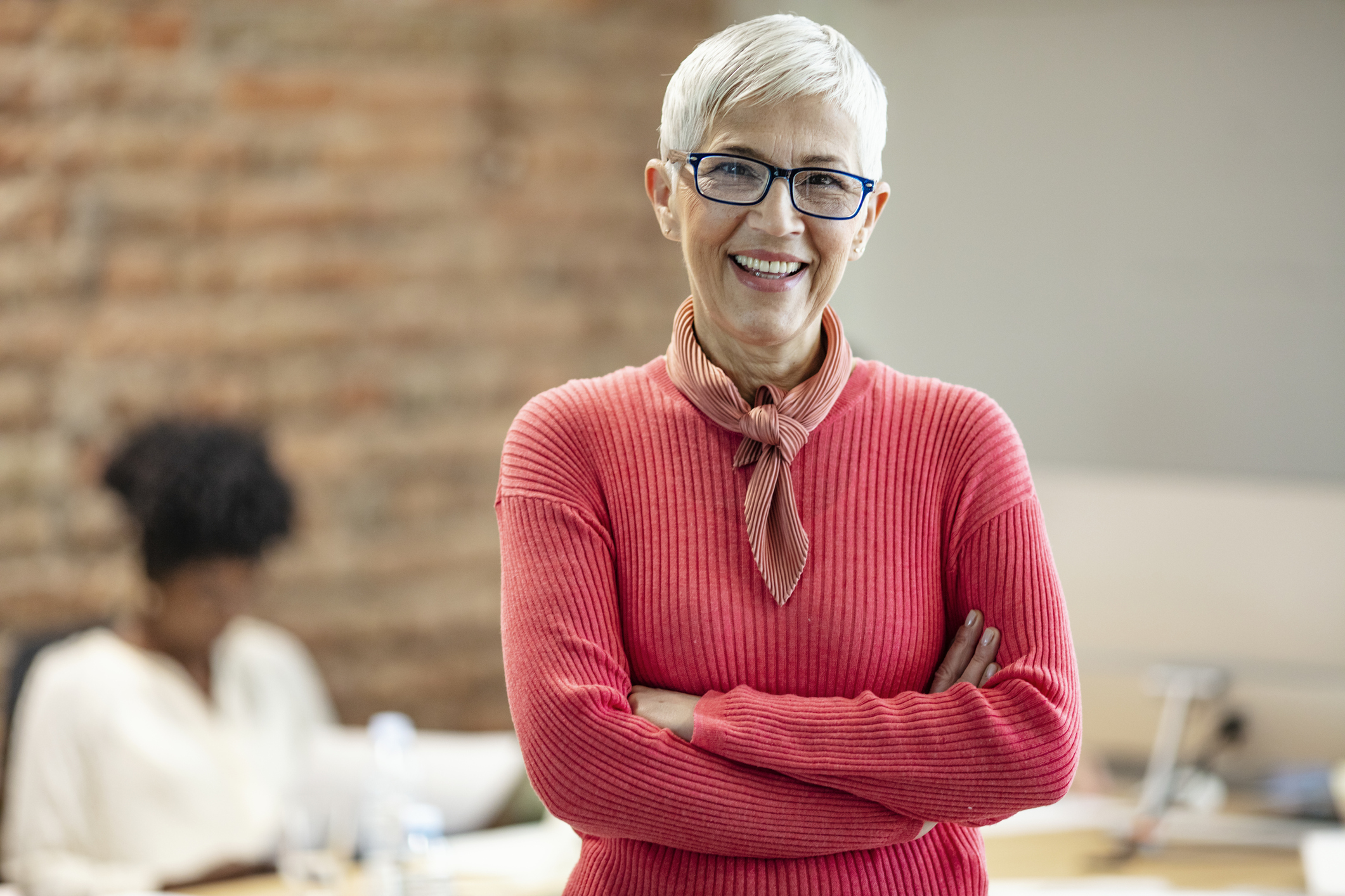 A friendly Financial Counsellor stands smiling at the camera in her office