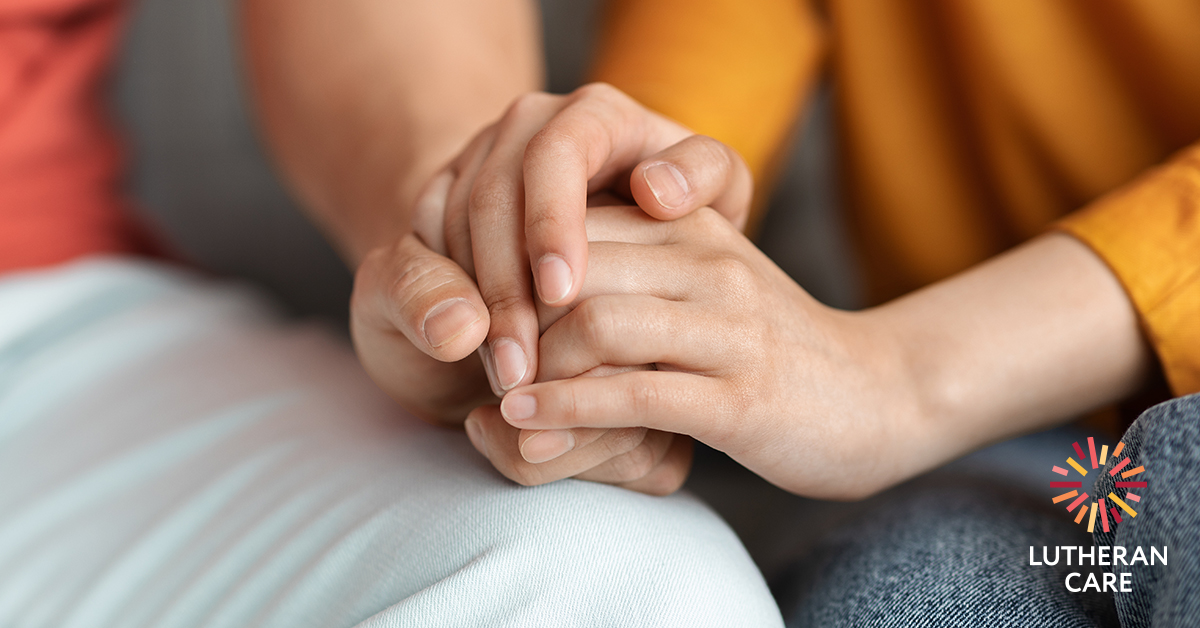 Image of two pairs of hands one is holding the others to offer comfort. The Lutheran Care logo appears in the bottom right hand corner.