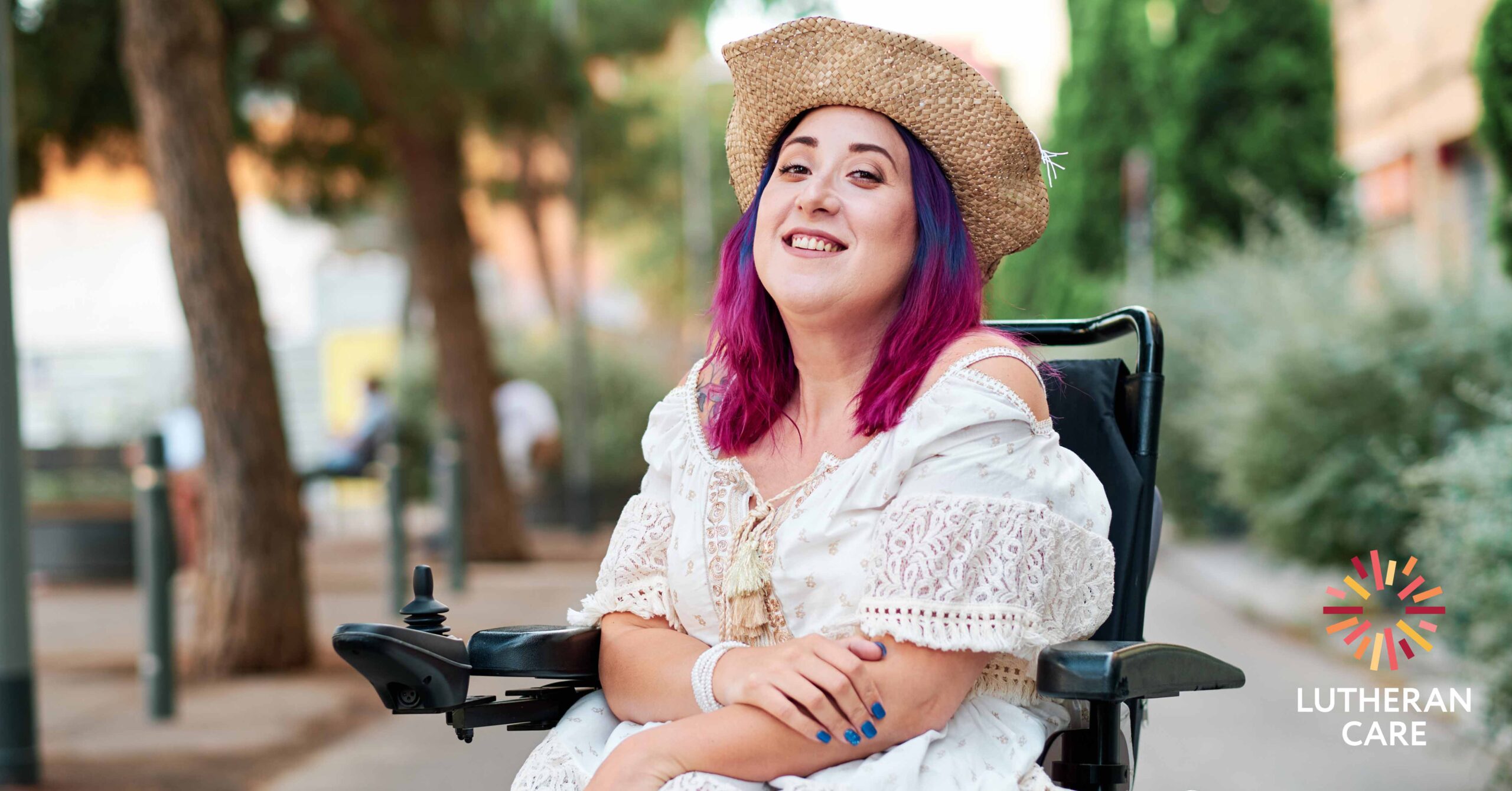 Young adult woman with disabiliites looking at camera. The Lutheran Care logo appears in the bottom right hand corner.