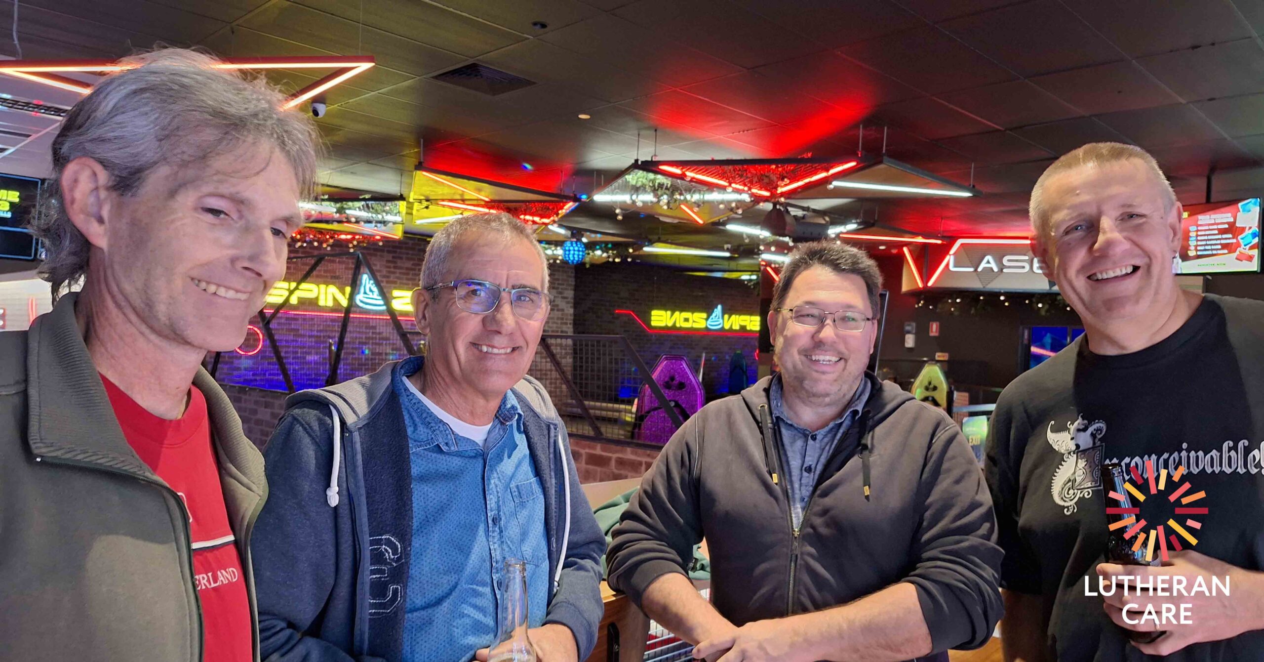 Foster Carers at a the bowling event. The Lutheran Care logo appears in the bottom right hand corner.