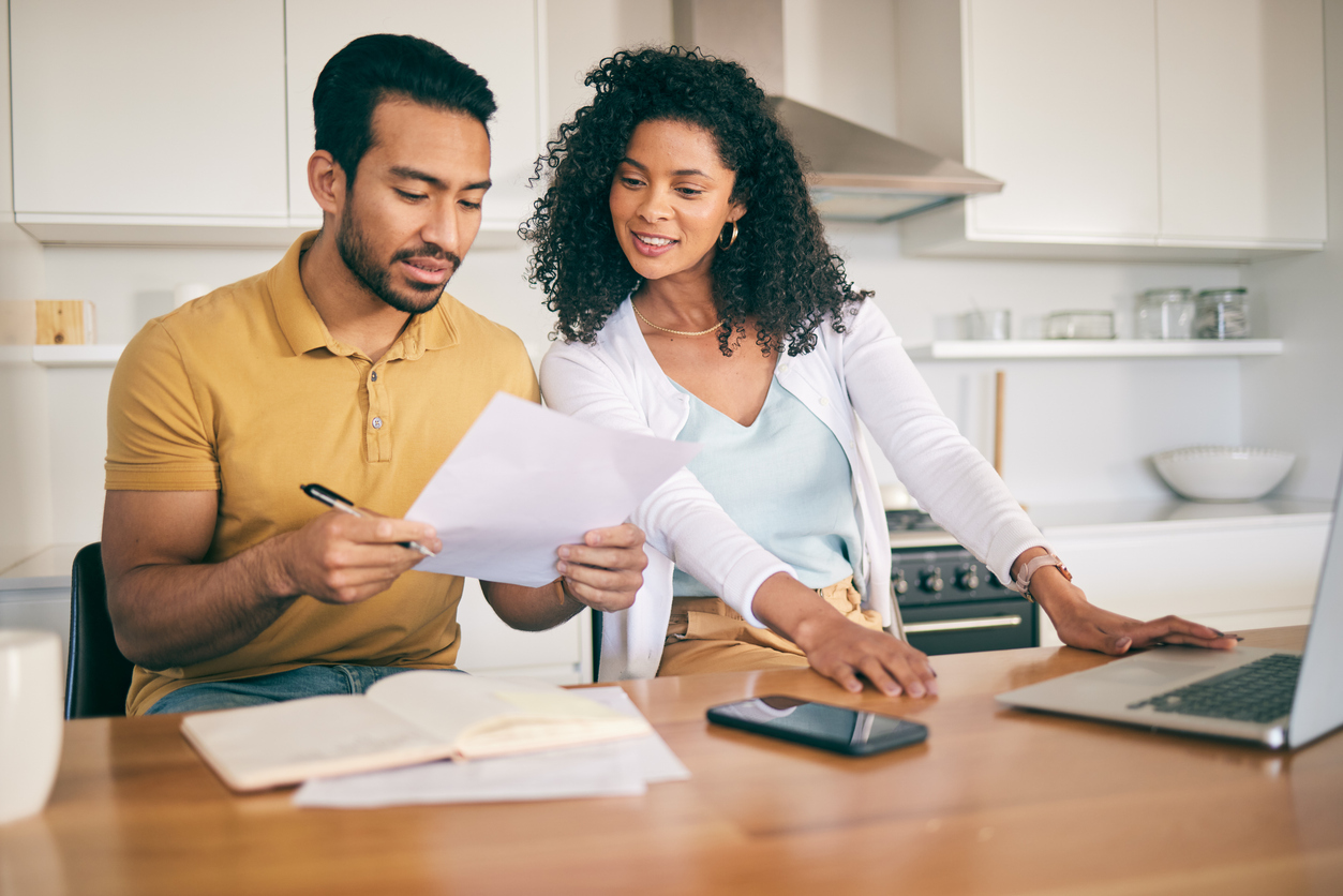 Couple sit at kitchen table going over their budget.