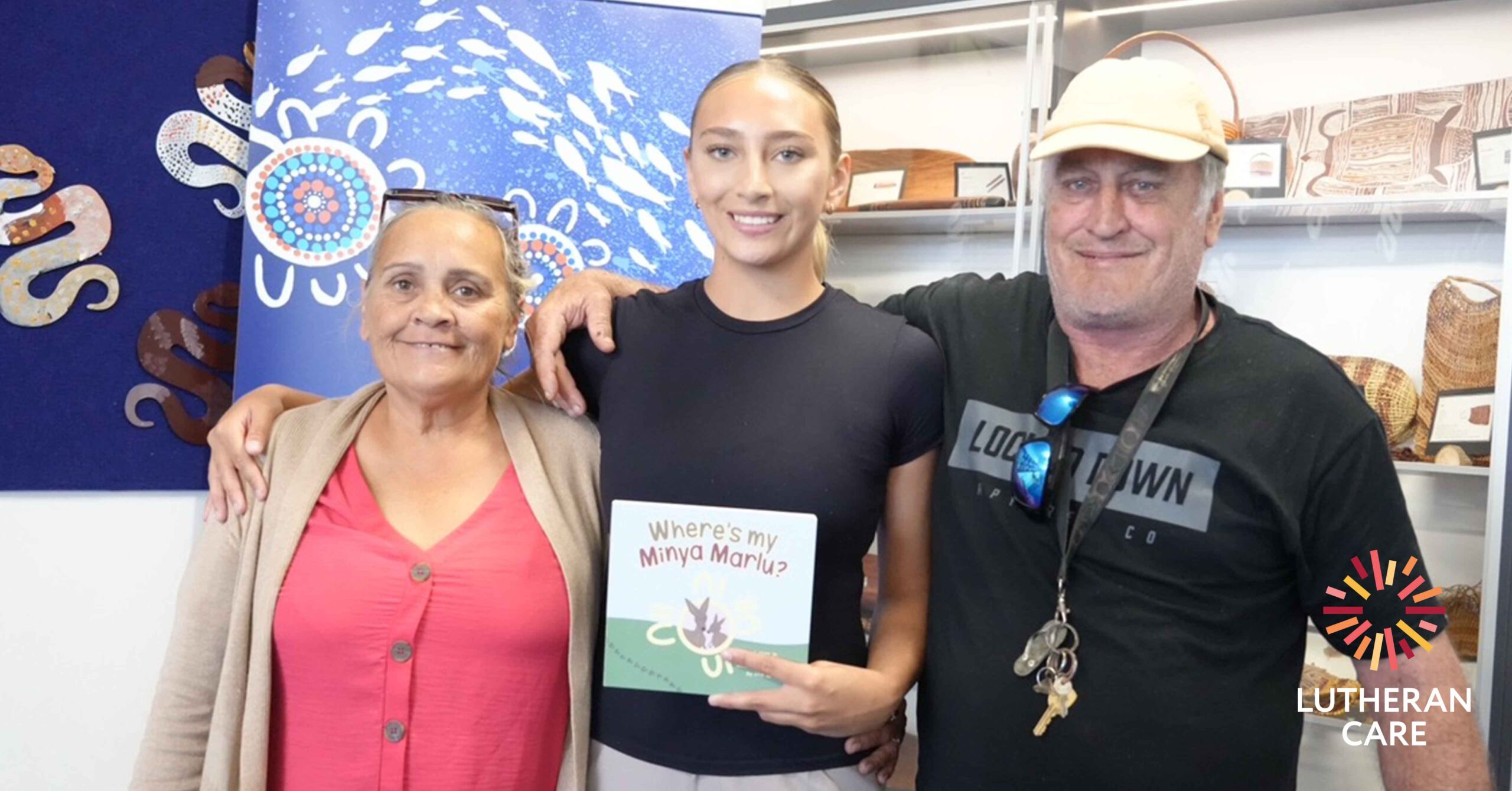 Mia with family holding her book. The Lutheran Care logo appears in the bottom right hand corner.