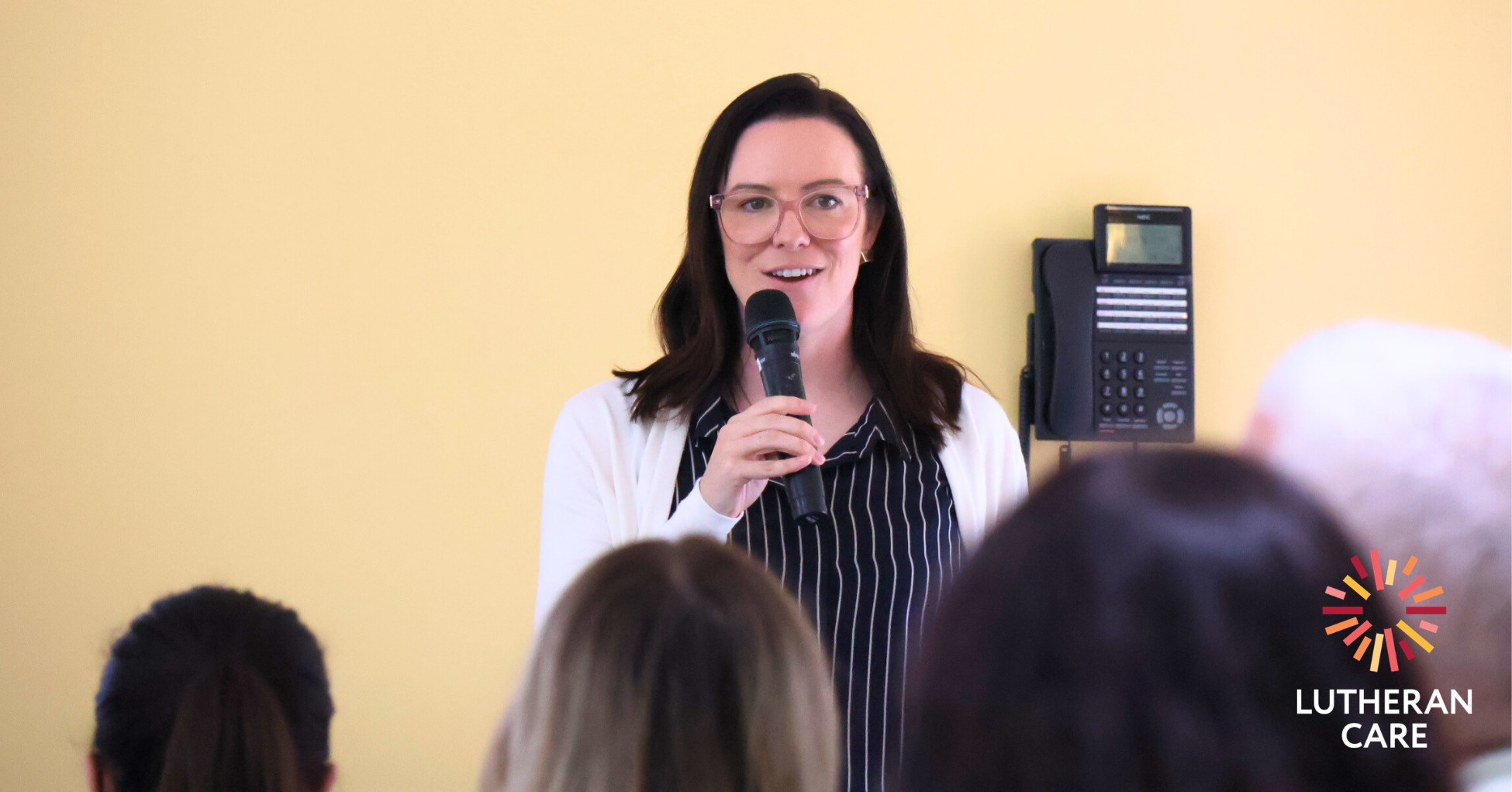 Image of Ash Hosking speaking at an event. The Lutheran Care logo appears in the bottom right hand corner.