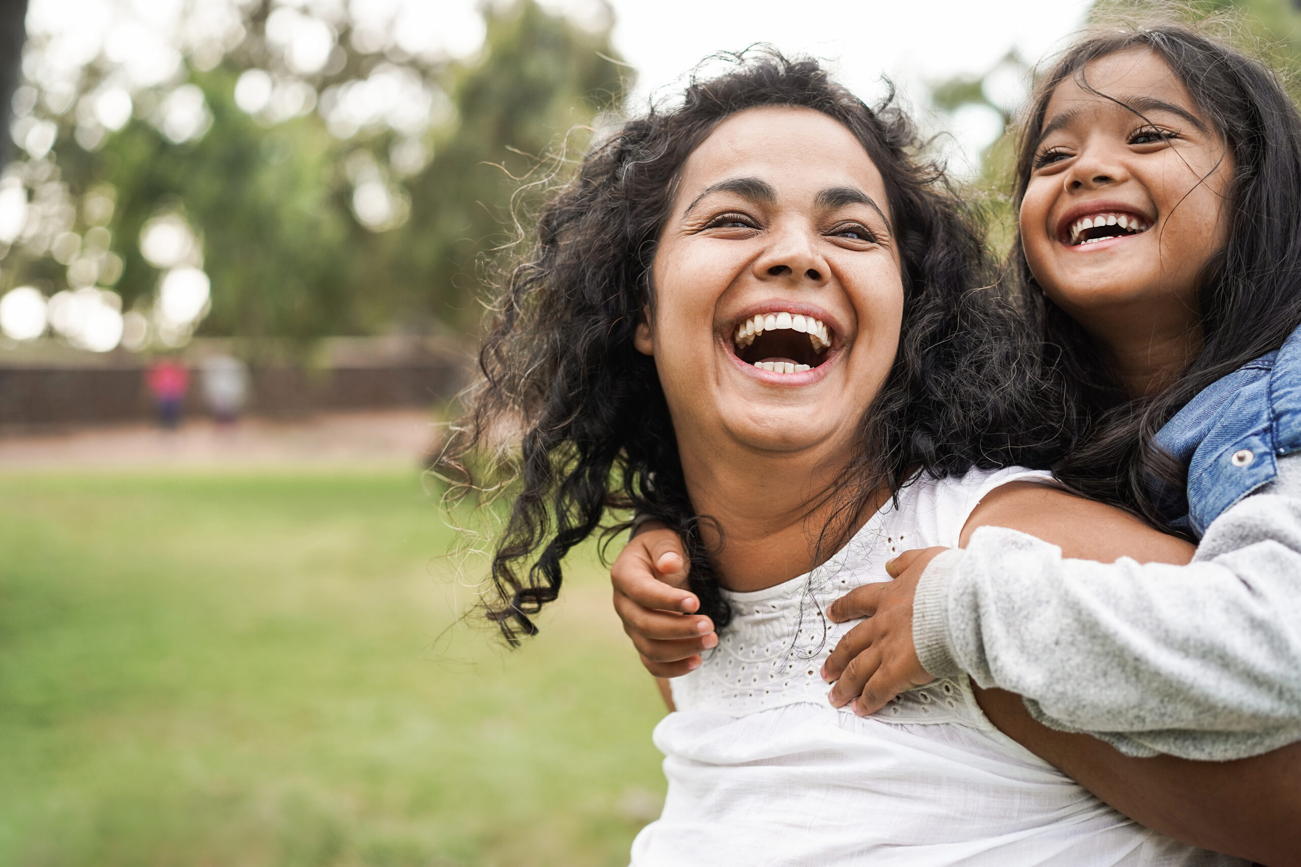 Laughing mother having fun with her happy daughter outdoor