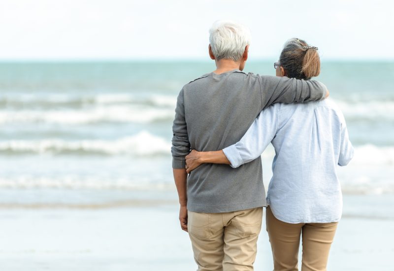 Asian Lifestyle senior couple hug and stand see beach happy in love romantic and relax time.  Tourism elderly family travel leisure destination and activity after retirement in vacations and summer.