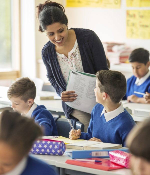 Teacher speaking with a student in her primary school class.